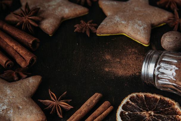 Composition of Christmas gingerbread in the shape of stars, spices and honey on a wooden table. Selective focus. - 写真・画像