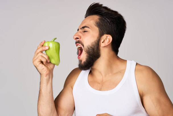 bebaarde man groene peper snack gezonde voeding emoties - Foto, afbeelding