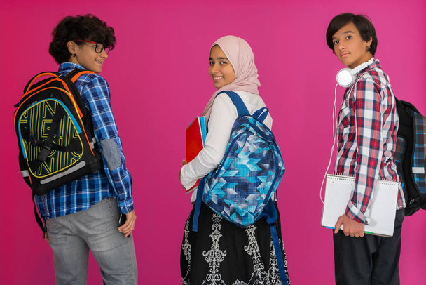 A group of Arab teenagers, a student team walking forward into the future and back to school the concept of a pink background. The concept of successful education for young people. Selective focus - Φωτογραφία, εικόνα
