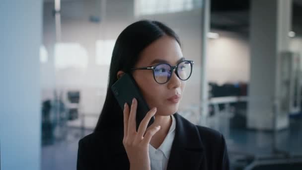 Asiática empresaria hablando por teléfono comunicándose en el trabajo en la oficina - Metraje, vídeo