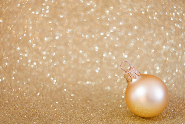 Glitter sparkling golden bokeh background with ball - Photo, Image