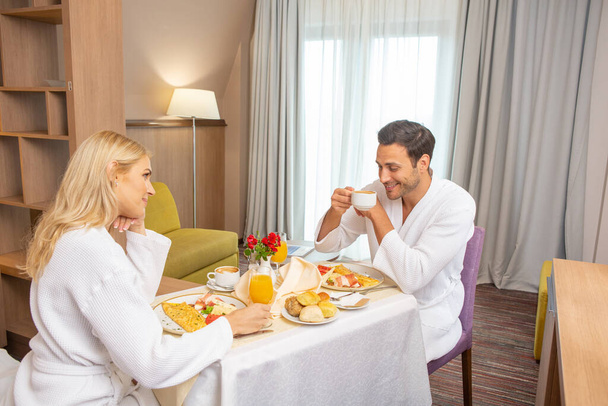 Happy couple having breakfast in hotel room - Foto, imagen