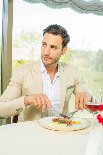 Attractive man having lunch in a hotel restaurant - Photo, Image