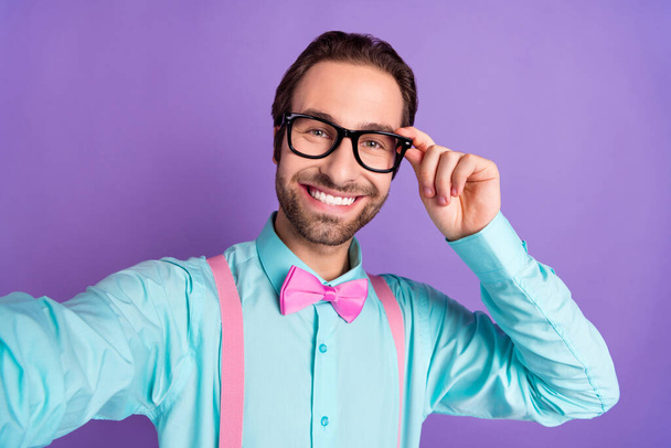Photo of millennial brunet guy cool do selfie wear tie suspenders blue shirt eyewear isolated on purple background - Fotó, kép