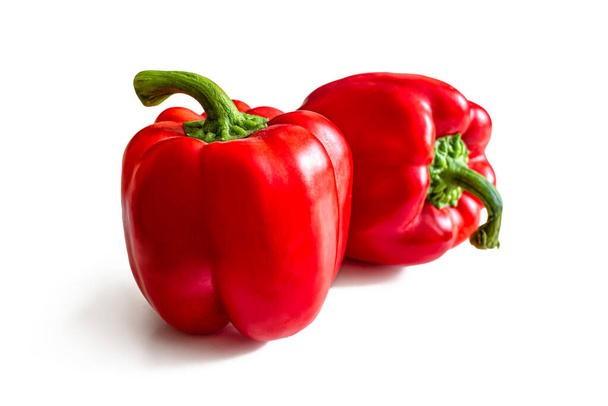 Ripe bell peppers with thick green cuttings and bright red skin, isolated on a white background - Photo, Image