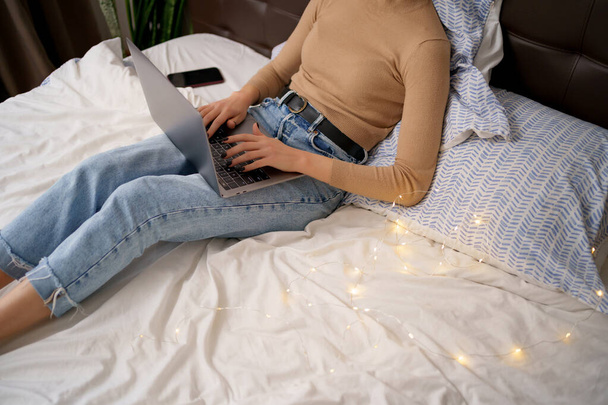 Женщина руки работают на компьютере в постели - Фото, изображение