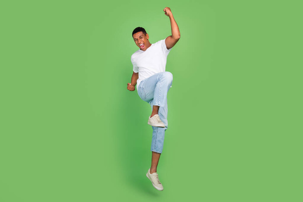 Full length photo of young excited african man celebrate victory win lottery isolated over green color background. - 写真・画像