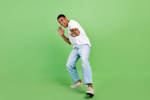 Full length photo of young cheerful african man have fun playful casual outfit isolated over green color background. - Fotoğraf, Görsel