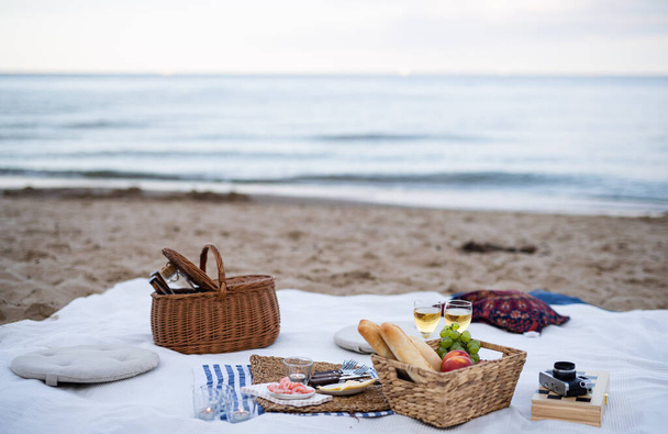 Beach picnic with schripms, beer, fruit and candles - Photo, Image