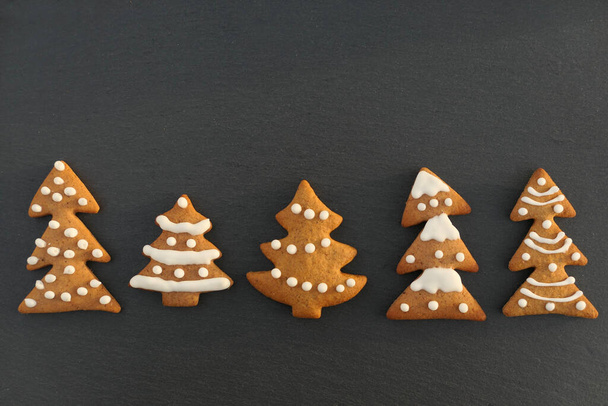 Christmas trees cookies collection on dark background. Christmas border. - Photo, image