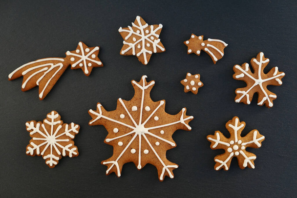 Gingerbread Christmas cookies snowflakes and stars on black background. - Fotografie, Obrázek