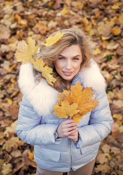 Good mood at any weather. girl on dry fallen leaves background. wear warm clothes. cozy and comfortable. autumn season fashion. beauty and style. woman with long hair in fall forest with leaves - Photo, image