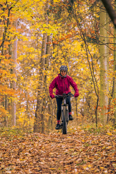 гарна старша жінка їде на своєму гірському велосипеді на осінніх лісових стежках біля Штутгарта, чудові теплі кольори, Баден-Вюртемберг, Німеччина. - Фото, зображення