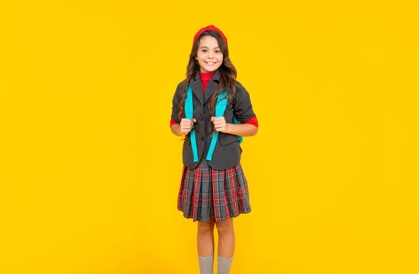 happy teen girl in uniform with school bag on yellow background, school - Fotoğraf, Görsel