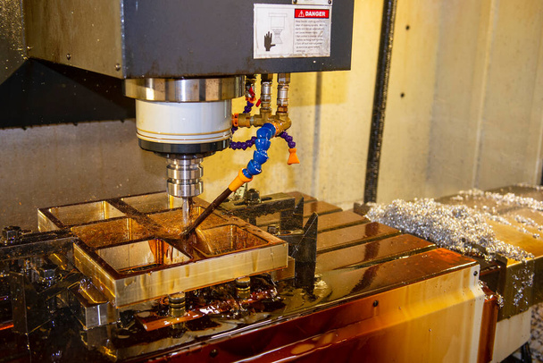 La fraiseuse CNC coupe les pièces de moule sous vide avec la méthode de refroidissement à l'huile. Le processus de fabrication de moules et de matrices par centre d'usinage CNC. - Photo, image