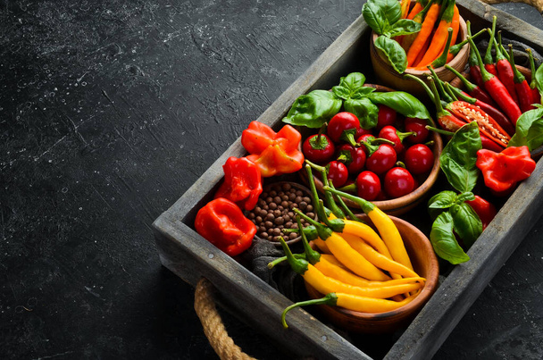 Set of colored chili peppers in a wooden box. Mexican cuisine. Spices. Top view. - Photo, Image