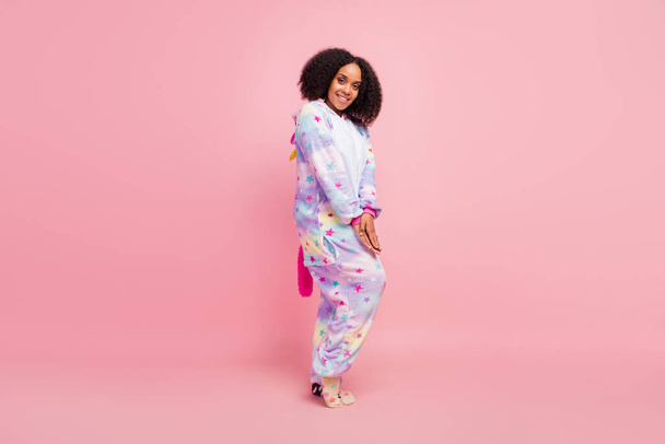 Full length profile side photo of young african girl wear soft kigurumi bedroom isolated over pink color background. - Foto, immagini