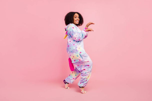 Full size profile side photo of young african woman have fun walk arms paws bedroom isolated over pink color background. - Fotó, kép