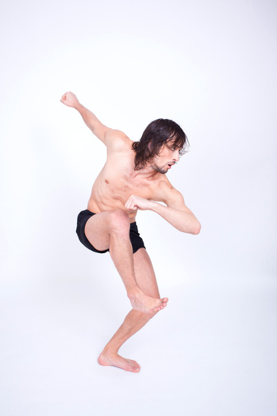Young attractive man dancing in studio - Фото, изображение