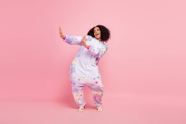 Full body photo of youth cheerful lady wear soft kigurumi dancing look empty space isolated over pink color background. - Фото, зображення