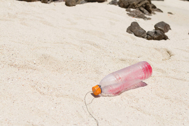 a szemetes műanyag palack volt szemét homokos tengerparton. - Fotó, kép