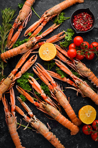 langoustines. Norway lobster on a black stone background. Raw scampi. Top view. Free copy space. - Foto, Bild