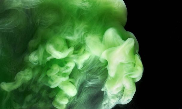Green smoke on black ink background, colorful fog, abstract swirling emerald ocean sea, acrylic paint pigment underwater - Фото, изображение