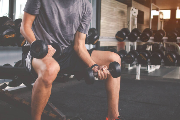 Primer plano de un hombre delgado haciendo ejercicios con mancuerna. Cuerpo muscular de fitness. Concepto Fitness - Foto, imagen
