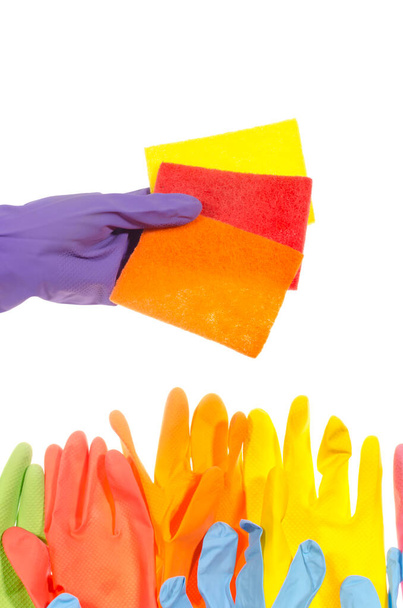 Farbige Latexhandschuhe zur Reinigung am Bildrand. Eine Hand in einem lila Latex-Handschuh hält farbige Lumpen zur Reinigung. Isoliert auf weißem Hintergrund. - Foto, Bild