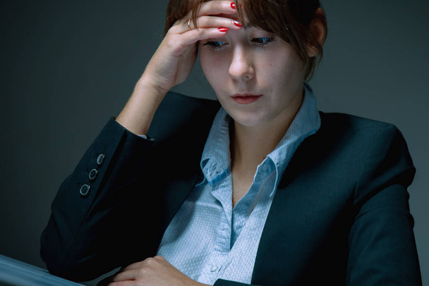 Portrait of unhappy and depressed business woman working in office as symbol of low wages, overtime working hours and lack of career prospects. Concept of professional burnout. - Фото, изображение