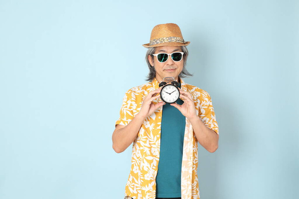 L'uomo asiatico anziano indossa estate vestito in piedi sullo sfondo blu. - Foto, immagini
