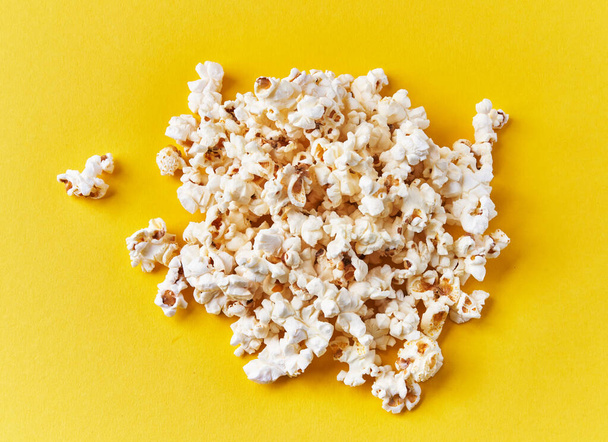  Bunch of salty popcorns on a yellow background - Foto, Imagem