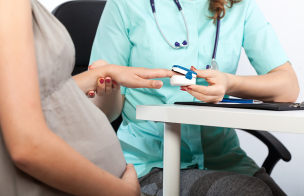 Pregnant woman during pulse measurement  - Photo, image