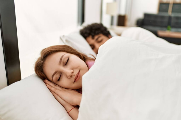 Молодая пара улыбается счастливый сон на кровати в спальне. - Фото, изображение
