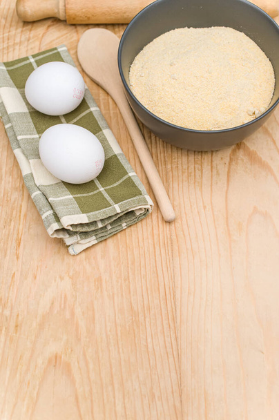 kitchen tools white eggs and dark gray bowl with wholegrain flour on worn wooden background with copy space - Φωτογραφία, εικόνα