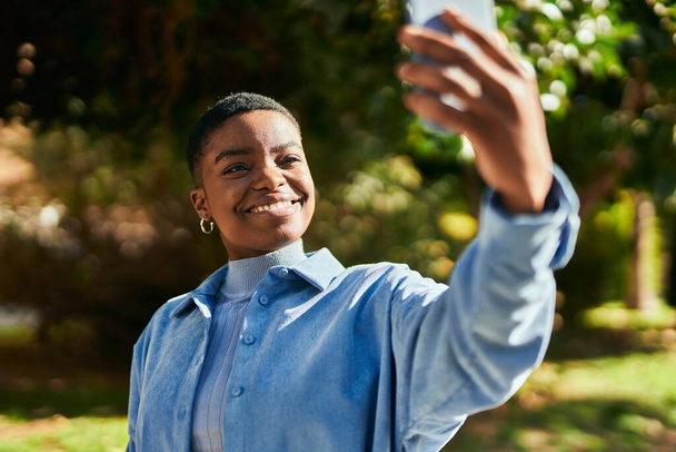 Nuori afrikkalainen amerikkalainen nainen hymyilee onnellinen tehdä selfie älypuhelimen kaupungin - Valokuva, kuva
