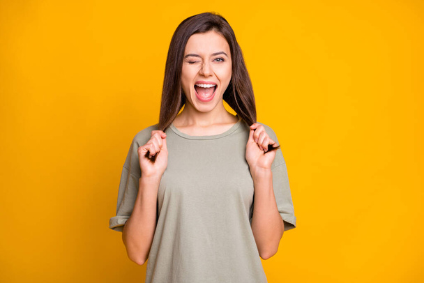 Portrait of lovely cheerful funny brown-haired girl winking making tails having fun isolated over bright yellow color background. - Фото, зображення