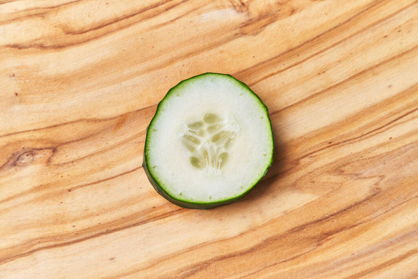  Slice of cucumber on a wooden table - Φωτογραφία, εικόνα