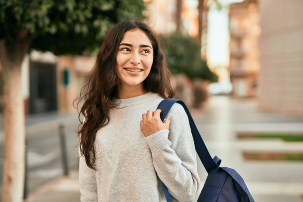 Молода студентка Близького Сходу посміхається щаслива стоячи в місті
. - Фото, зображення