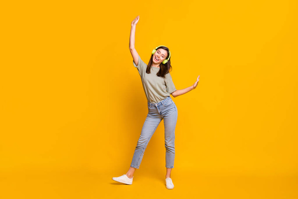 Full length body size view of charming carefree cheerful girl listening melody having fun isolated over bright yellow color background. - Photo, image