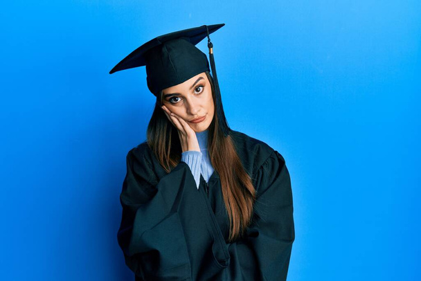 Beautiful brunette young woman wearing graduation cap and ceremony robe thinking looking tired and bored with depression problems with crossed arms.  - Valokuva, kuva
