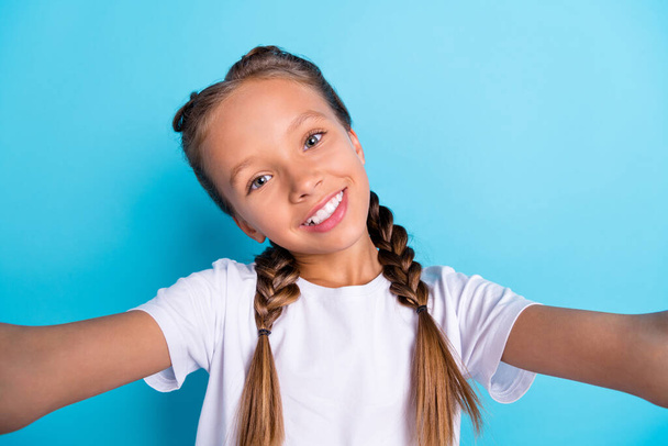 Photo of young little girl happy positive smile make selfie blogger video recording isolated over blue color background. - Φωτογραφία, εικόνα