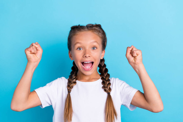 Photo of young girl happy positive smile rejoice win victory success fists hands isolated over blue color background. - Zdjęcie, obraz