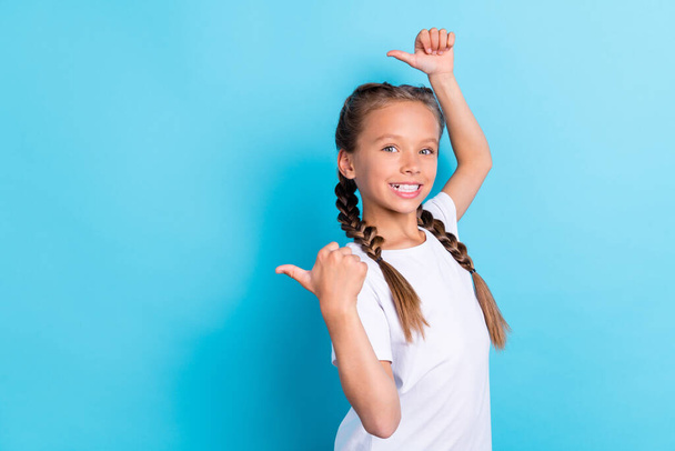 Profile side photo of young little girl happy positive smile show thumbs empty space suggest advise ads isolated over blue color background. - Foto, imagen
