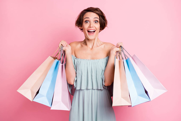 Photo of young excited girl happy positive smile surprised shopping bags black friday sale isolated over pastel color background. - Photo, Image