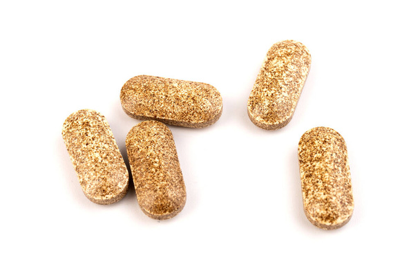 Medical, herb herbal tablets. Nutrition supplements, brown vitamin pills on white background - Photo, Image
