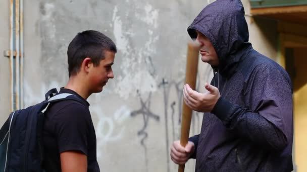 Homme avec une batte de baseball parlant avec un adolescent
 - Séquence, vidéo