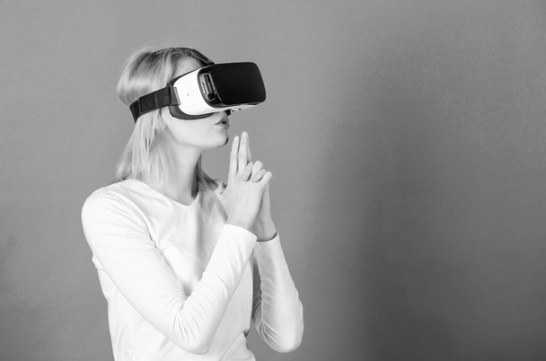 Woman excited using 3d goggles. Young woman using a virtual reality headset. Amazed young woman touching the air during the VR experience. VR image. - Фото, зображення
