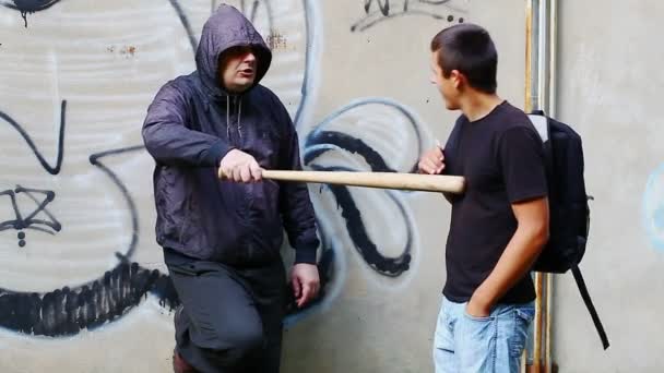 Man with a baseball bat talking with teenager - Footage, Video