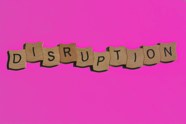 Disruption, word in wooden alphabet letters isolated on blue background as banner headline with effects added - Photo, Image